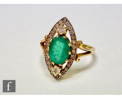 An 18ct hallmarked emerald and diamond ring, central oval emerald within a diamond set above and below, all within a diamond 