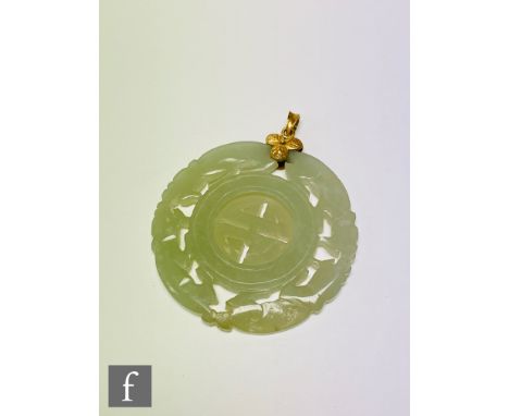 A mid 20th Century 14ct and jade pendant, the circular carved jade with central spinning panel all below 14ct flower detail a