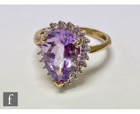 A 9ct hallmarked amethyst and diamond cluster ring, central pear shaped amethyst, length 16mm, within a diamond surround, all