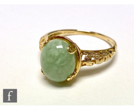 A 14ct gold jade set ring, the pale green stone, set within a reticulated shank with wrythen dragon design, 3.6g weight, ring