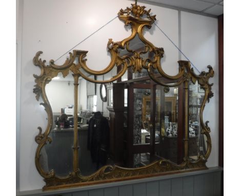 A CHIPPENDALE STYLE CARVED AND GILTWOOD OVERMANTLE MIRROR, of elaborate scrolling form, 148 cm wide, 132 cm high