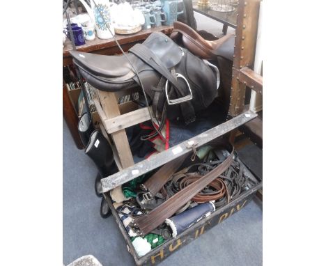 EQUESTRIAN INTEREST; TWO LEATHER SADDLES with wooden stand, riding boots, whips and a Vintage tin trunk containing horse ridi