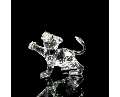 Miniature lion figurine made of clear crystal for the head and the body. The right paw is sticking outwards, and the tail is 