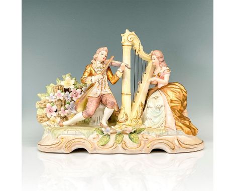 Figural ceramic lamp featuring a man and woman in 18th century dress playing musical instruments. Gold gilt and sculpted flow