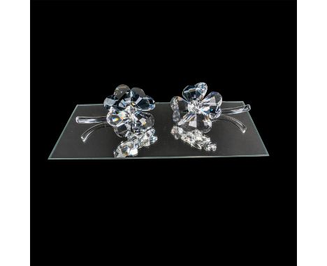 Two delicate flowers with four leaves, made in faceted clear crystal, sit on smooth clear crystal stems. This item has a base