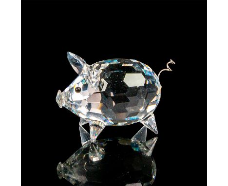 Faceted crystal figurine modeled as a little round pig with black eyes, spiked crystal feet, and a silver wire coil tail. Swa