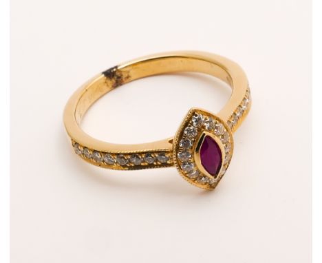 An 18ct gold ruby and diamond cluster ring set with a Marquise shaped ruby surrounded by diamonds with diamond shoulders in 1