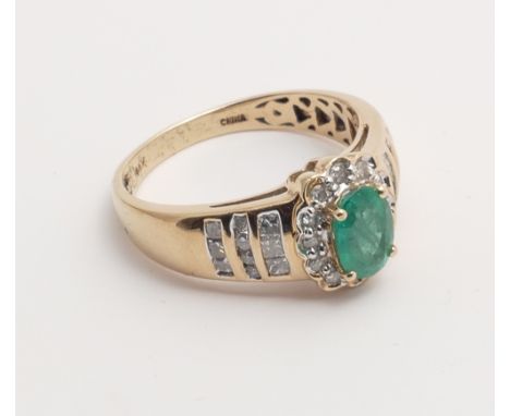 A 14ct yellow gold emerald and diamond cluster ring set with an oval mixed cut emerald surrounded by brilliant cut diamonds w