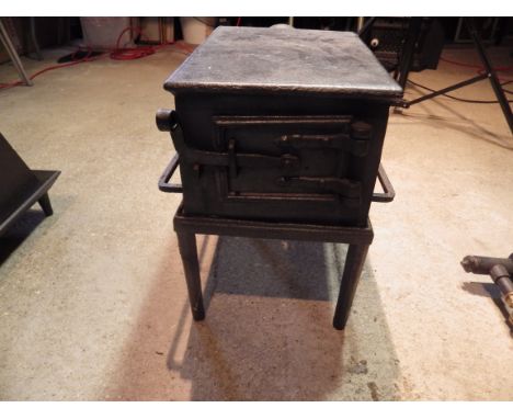 Large cast iron stove with grate and latch door on stand, stove is 34cm x 25cmx 19cm tall
