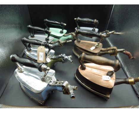 7 assorted Davis gas irons incl an early model with wood handle and flush sole, includes enamel models, 4 with trivets, 2 wit