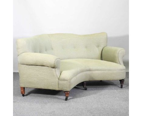 A Victorian patent green upholstered corner sofa, in the manner of Howard &amp; son, later upholstered in green, with a butto