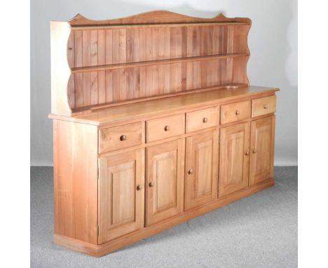 A handmade light ash dresser base, of large proportions, fitted with cupboards and drawers, with a shelved back243w x 46d x 1