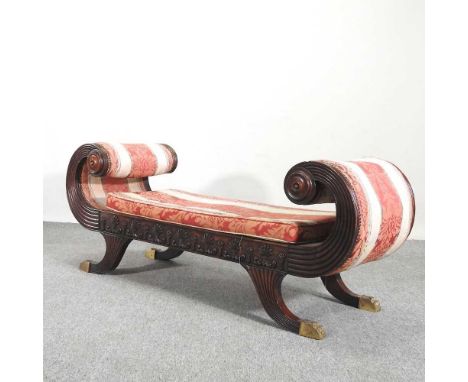 A good quality Regency style carved mahogany window seat, 20th century, having scrolled ends, with a loose cushion, on sabre 