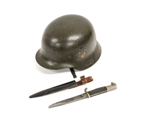 A Second World War Geman M35 Combat Helmet, with dark green finish, later Heer decal, folded rim, the left side of the inner 