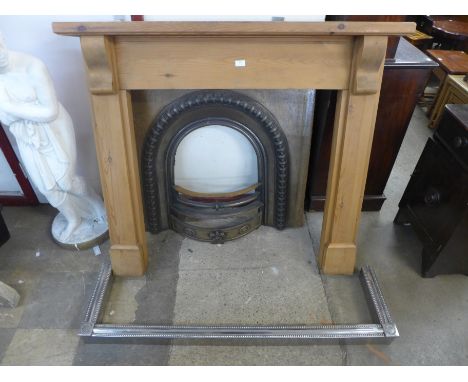 A cast iron fire insert, with pine surround and an Art Deco steel fender 