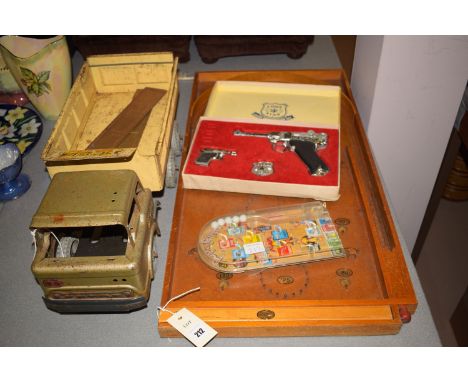 A bagatelle; a toy truck; a toy Luger presentation set, by Lone Star; and a small miniature bagatelle game.