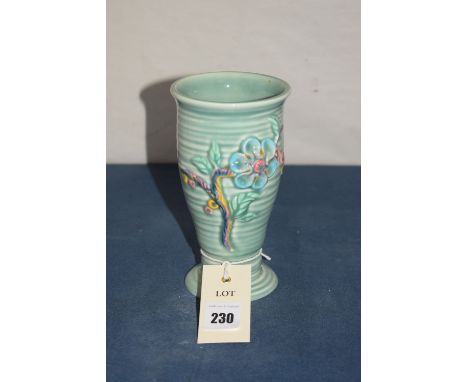 A Clarice Cliff design vase, shape no. 913 by Newport Pottery, with raised stylized floral decoration on green glazed ground.