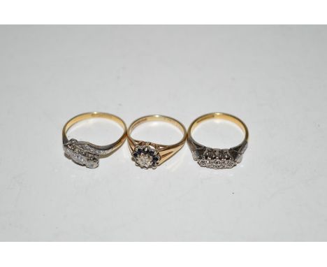 A three stone diamond ring set in white metal, on yellow metal shank stamped '18ct & plat', ring size K; together with anothe