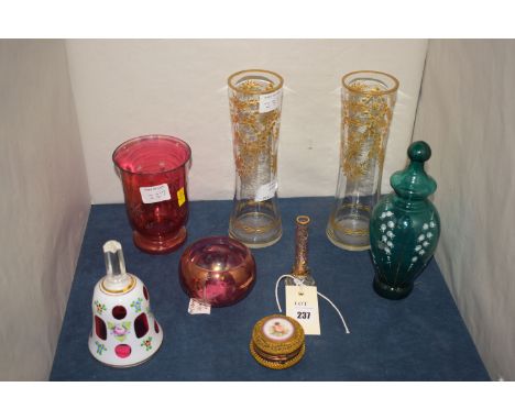 A cranberry glass and gilded metal pill box, with enamel panel depicting a putti; a green tinted glass vase and cover, with h