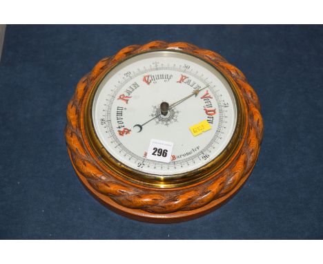 A aneroid barometer in circular oak rope twist carved case.