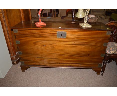 A reproduction Georgian style mahogany blanket box, the hinged top above metal bound base, raised on bracket feet, 86cms high