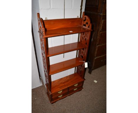 A reproduction hanging shelf unit, fitted four short drawers and pierced sides, 111cms. high.