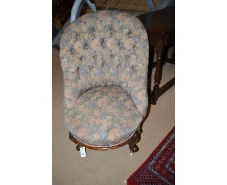 A Victorian easy chair, the buttoned back and seat upholstered in floral material, raised on scrolling feet and ceramic casto