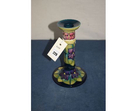 A modern Moorcroft candlestick, with stylized tube lined decoration on dark blue ground.