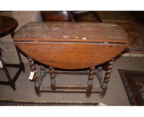 A 19th Century oak drop leaf table, the associated top raised on barley twist legs fitted gate action.