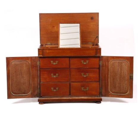 A 19TH CENTURY GENTLEMANS CAMPAIGN DRESSING CHEST with hinged rising lid, adjustable mirror and numerous compartments, the in