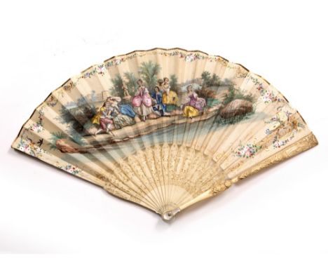 AN ANTIQUE CONTINENTAL IVORY AND SILK PAINTED FAN decorated figures seated in a formal garden, each stick with finely carved 