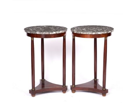 A PAIR OF EMPIRE STYLE MAHOGANY CIRCULAR LAMP TABLES with marble tops and on three tapering supports and triform base, 49cm d
