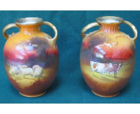 PAIR OF ROYAL DOULTON GILDED TWO HANDLED CERAMIC VASES DEPICTING HIGHLAND CATTLE AND SHEEP, APPROXIMATELY 16cm HIGH 