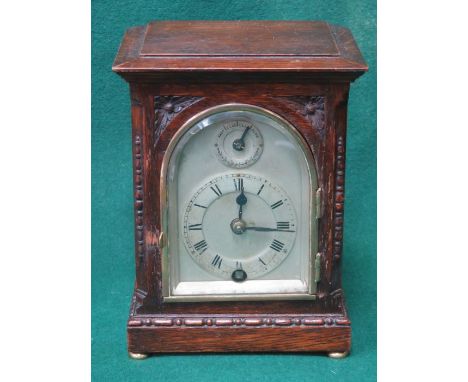 CARVED FRONTED OAK CASED SMALL BRACKET CLOCK WITH SILVER COLOURED DIAL, APPROXIMATELY 16cm HIGH 