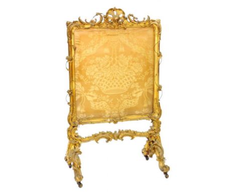 AN ORNATE VICTORIAN GILTWOOD AND COMPOSITION FIRESCREEN WITH (FRAYED) FABRIC BANNER (LOSSES)