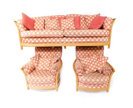 An Ercol light elm three piece suite, comprising a two seater sofa, 215cm wide, together with a pair of armchairs.