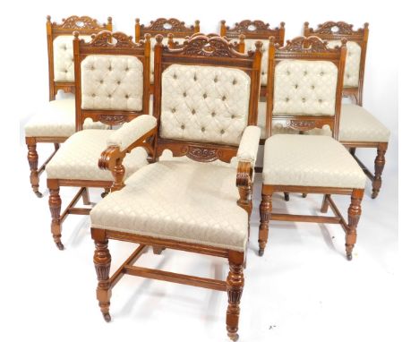 A set of eight Victorian oak dining chairs, with carved crest rails, button backs and over stuffed seats, raised on fluted an