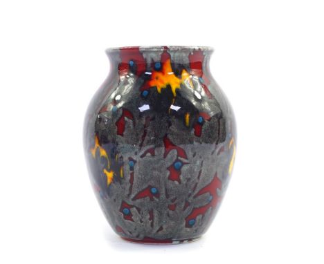 A Poole Pottery flame vase, decorated in silver with a sea weed pattern, against a red ground, raised marks, 17cm high.