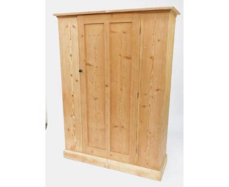 A Victorian pine hall cupboard, single door opening to reveal a shelf and hanging hooks, raised on a plinth base, 185cm high,