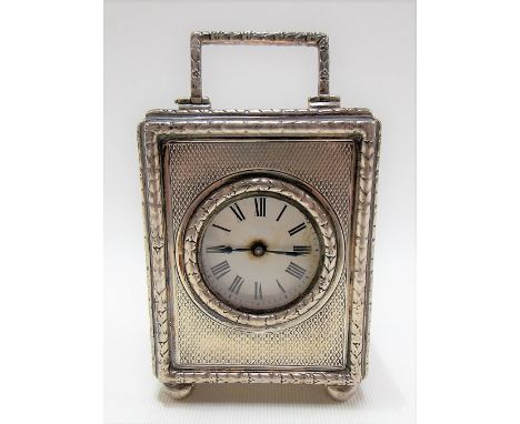 George V silver case miniature carriage timepiece, the engine turned case with harebell borders and raised on four ball feet,