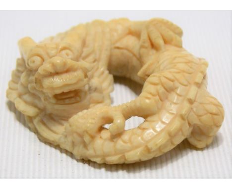 Japanese Meiji period carved ivory netsuke modelled as a coiled dragon, signed, width 4.5cm