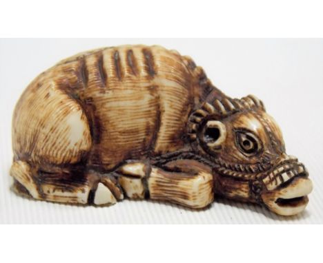 Japanese Meiji period carved ivory netsuke modelled as a reclining buffalo, signed, length 5cm