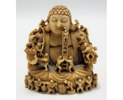 Good Japanese ivory Meiji period netsuke in the form of a portly Buddha statue being built by many figures, signed to the bas