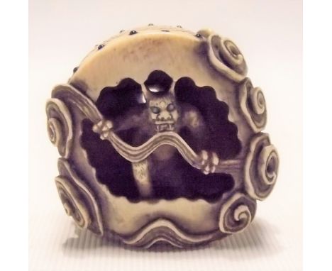 Japanese ivory Meiji period netsuke carved and pierced in the form of a demon amongst clouds, signed, height 3.5cm
