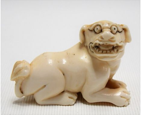 Japanese Meiji period ivory carved netsuke modelled as a mythological dog, signed, length 5.5cm