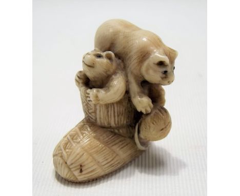 Japanese ivory Meiji period netsuke carved as two kittens in a woven slipper, one playing with a ball of yarn, signed to the 