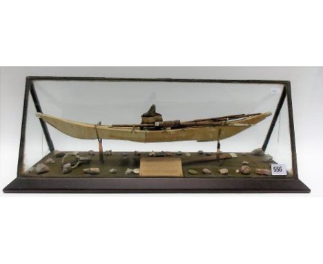 A leather bone and wood model of an 'esquimaux kayak' within a glazed case and with paper label which reads 'Brought from Dis