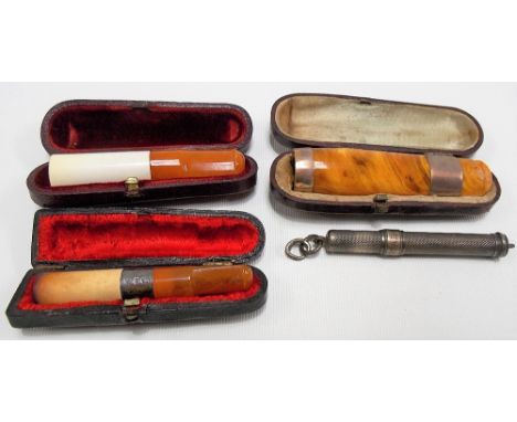 Three cased cheroot holders with amber mouthpieces; together with a silver plate engine turned propelling pencil (4)