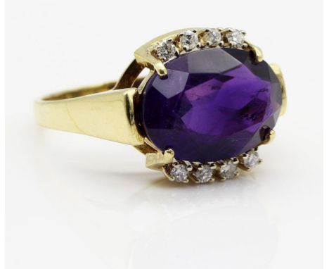 Damenring. 585/000 GG, brutto 4,7 g. Besetzt mit qualitätvollem, oval facettierten Amethyst und acht Brillanten, zus. ca. 0,1