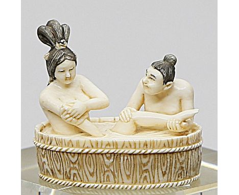 Netsuke "Mann und Frau beim Bade". Elfenbein, geschnitzt. Himotoshi auf der Unterseite. Altersspuren. Unterseite mit Sign. in
